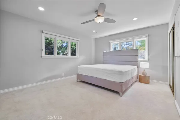 a spacious bedroom with a bed and ceiling fan