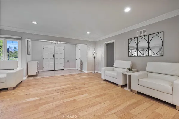 a spacious bedroom with a white bed and white walls