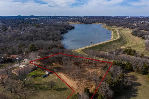 an aerial view of a house with a yard and lake view