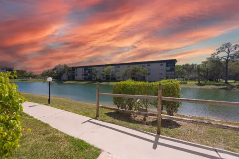 a view of a lake with a floor to ceiling window next to a yard