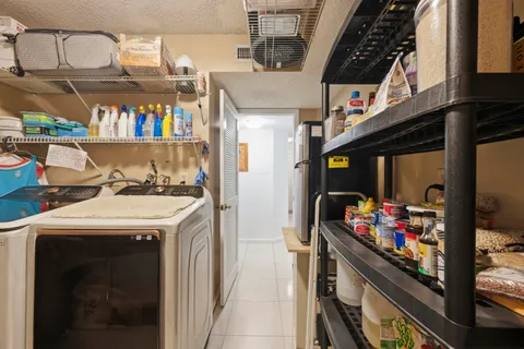 a spacious bedroom with a large bed a chandelier a mirror on the dresser and chandelier