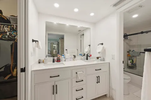 a view of a hallway with bathroom and shower