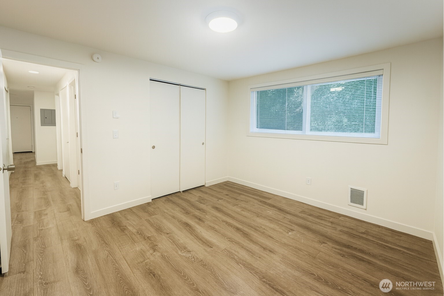 11211 Northeast 68th Street, Unit 3 Kirkland, WA 98033 - Photo 11 of 21 a view of an empty room with wooden floor and a window