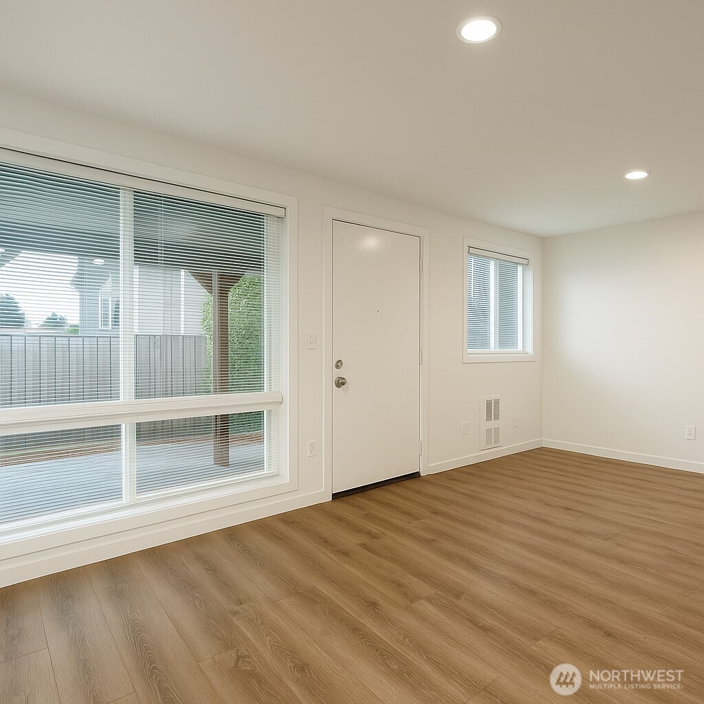 11211 Northeast 68th Street, Unit 3 Kirkland, WA 98033 - Photo 2 of 21 an empty room with wooden floor and windows