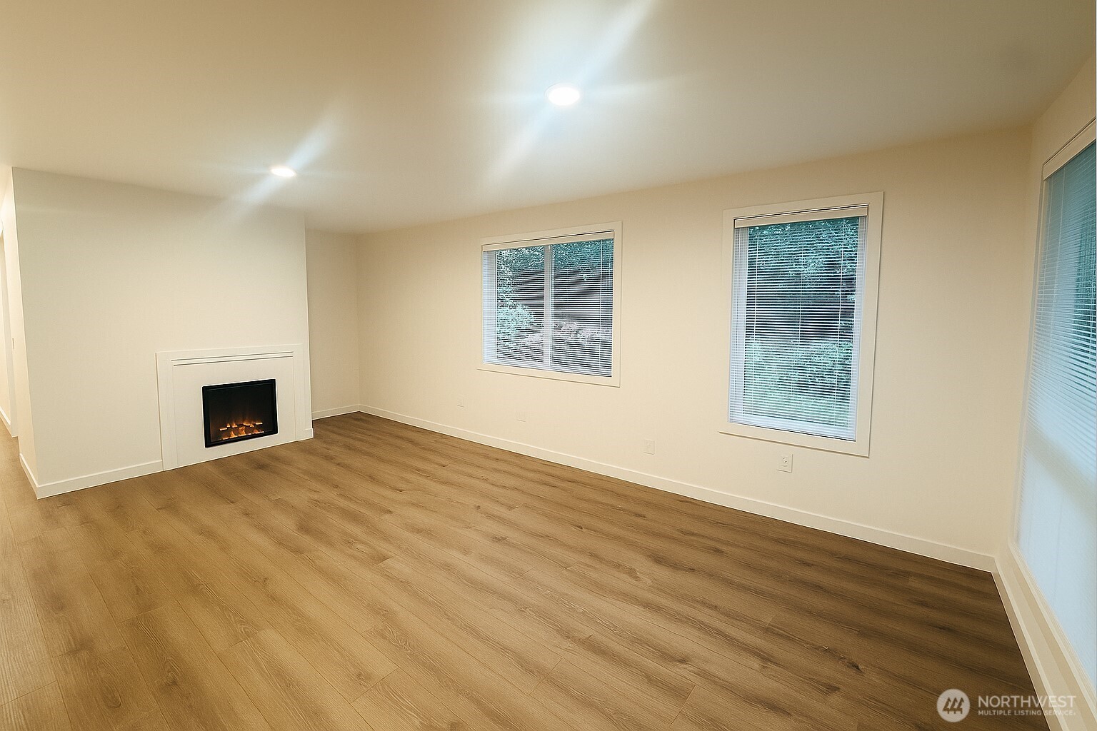 11211 Northeast 68th Street, Unit 3 Kirkland, WA 98033 - Photo 4 of 21 a view of an empty room with wooden floor and a window
