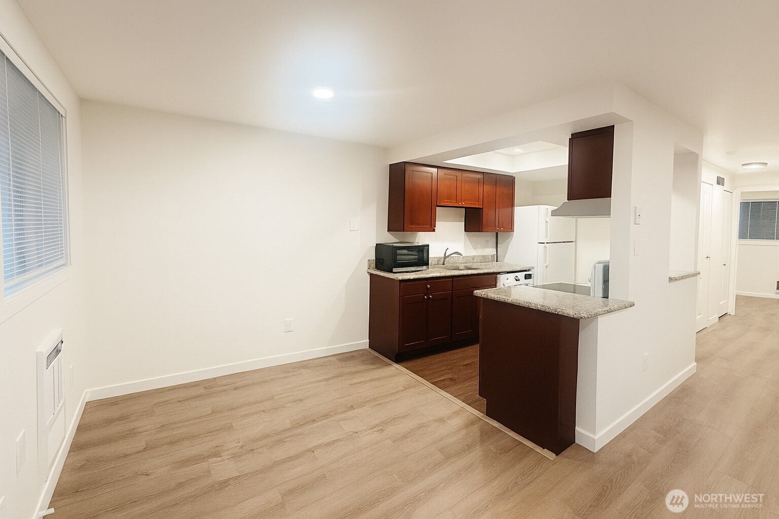 11211 Northeast 68th Street, Unit 3 Kirkland, WA 98033 - Photo 5 of 21 a kitchen with granite countertop a sink and a stove top oven
