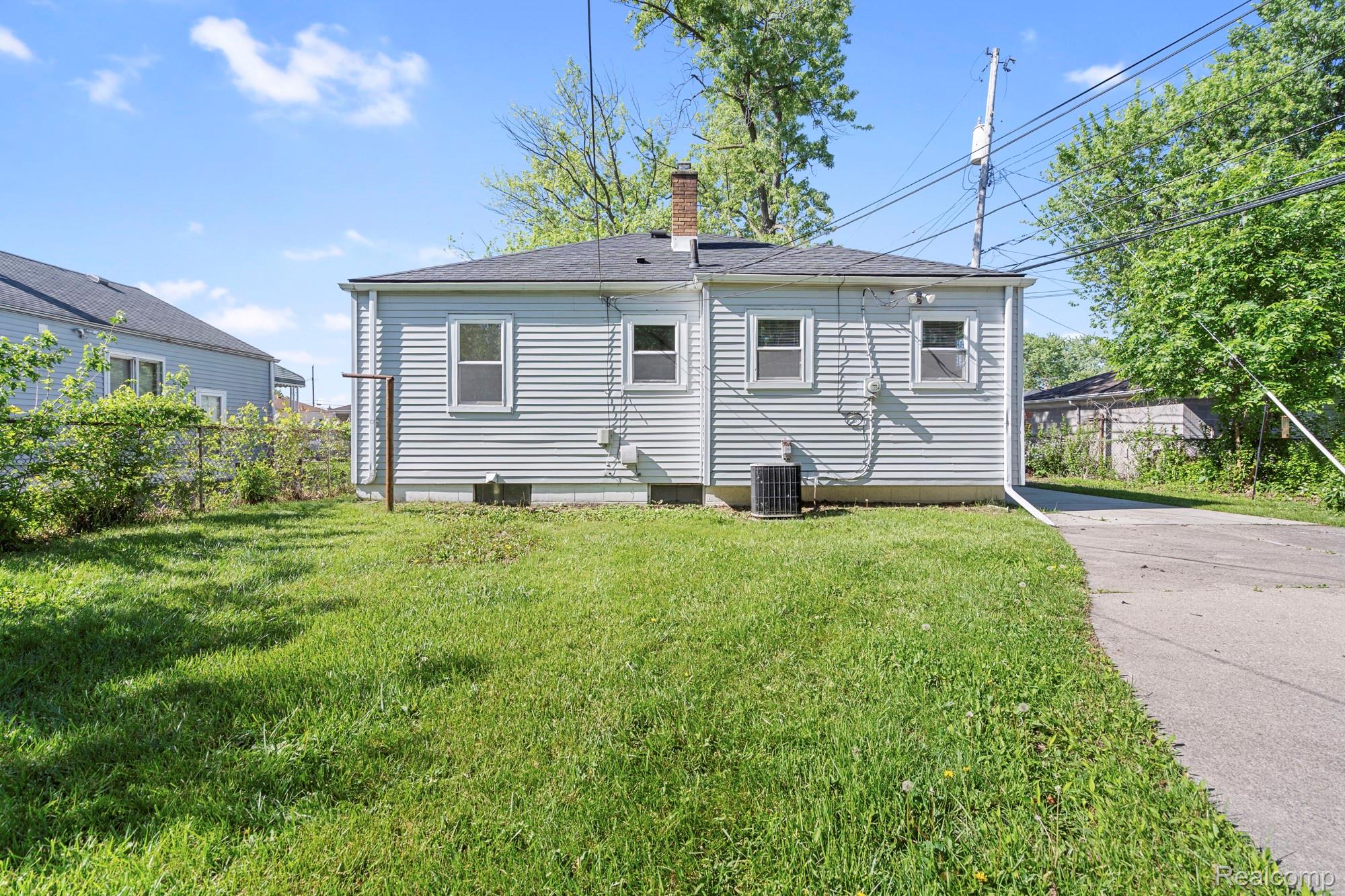 970 Champaign Road Lincoln Park, MI 48146 - Photo 28 of 28 Back of property featuring a chimney and a shingled roof