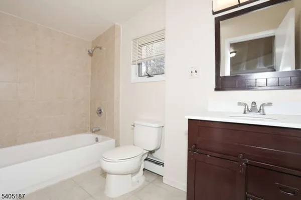 a bathroom with a toilet a sink a mirror and a bathtub