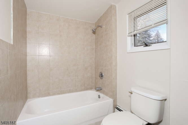 68 Mohawk Avenue Hawthorne, NJ 07506 - Photo 13 of 24 a white bath tub sitting next to a white toilet
