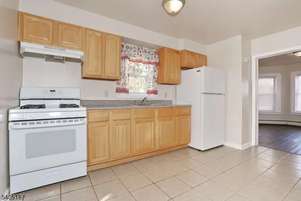 a kitchen with white cabinets and white appliances