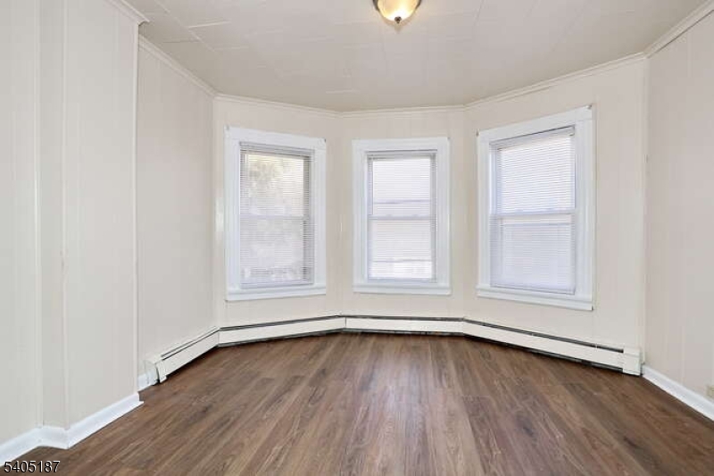 68 Mohawk Avenue Hawthorne, NJ 07506 - Photo 8 of 24 an empty room with wooden floor and windows