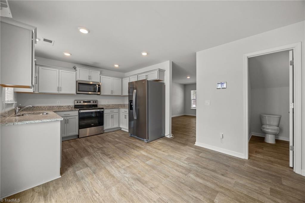 4604 Heatherly Road Winston-Salem, NC 27105 - Photo 31 of 31 Open floor plan with LVP flooring throughout lower level