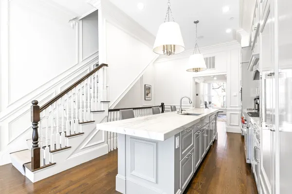 a kitchen with kitchen island a white cabinets and appliances