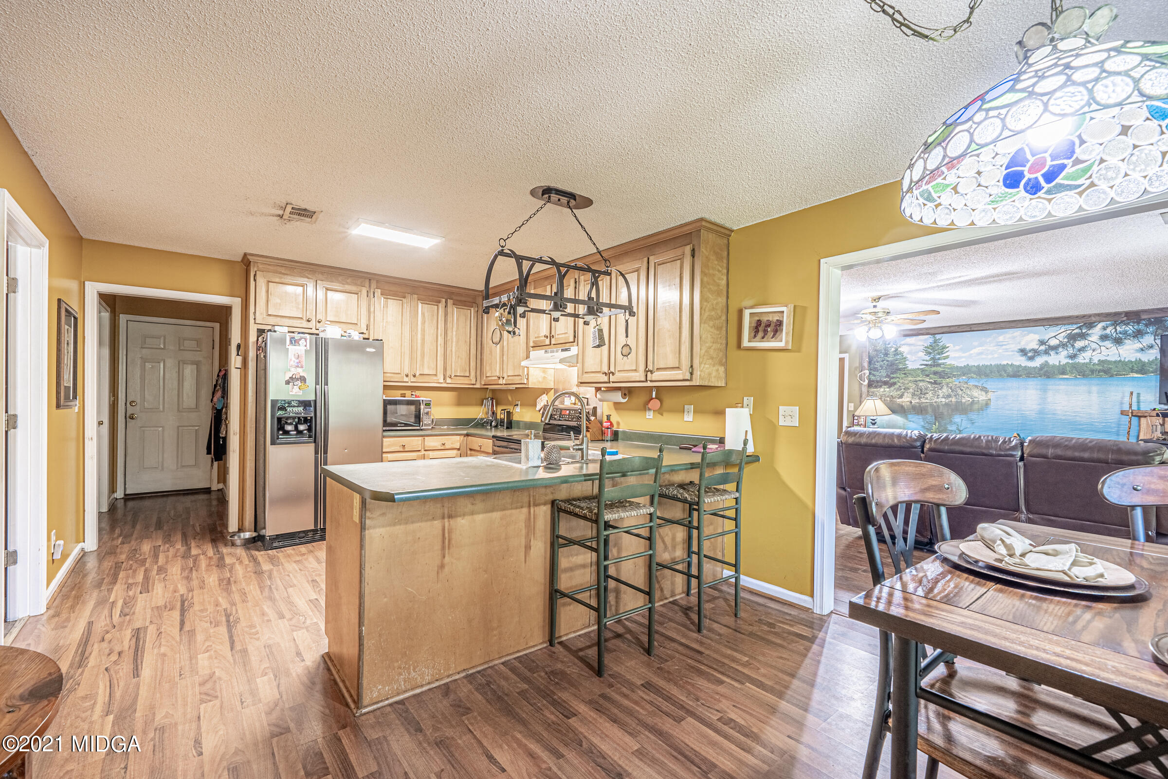 239 Plantation Road Gray, GA 31032 - Photo 11 of 28 a kitchen with stainless steel appliances wooden floor and dining table