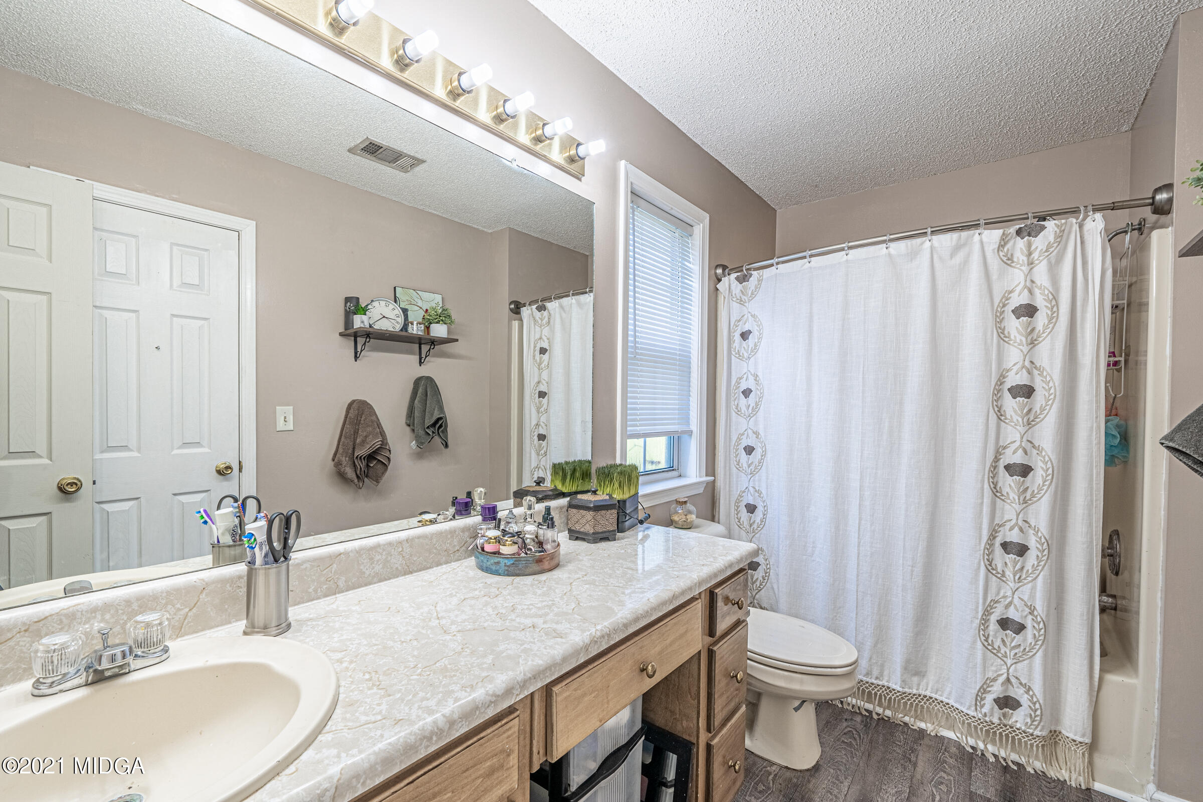 239 Plantation Road Gray, GA 31032 - Photo 17 of 28 a bathroom with double vanity sinks a toilet a mirror and shower