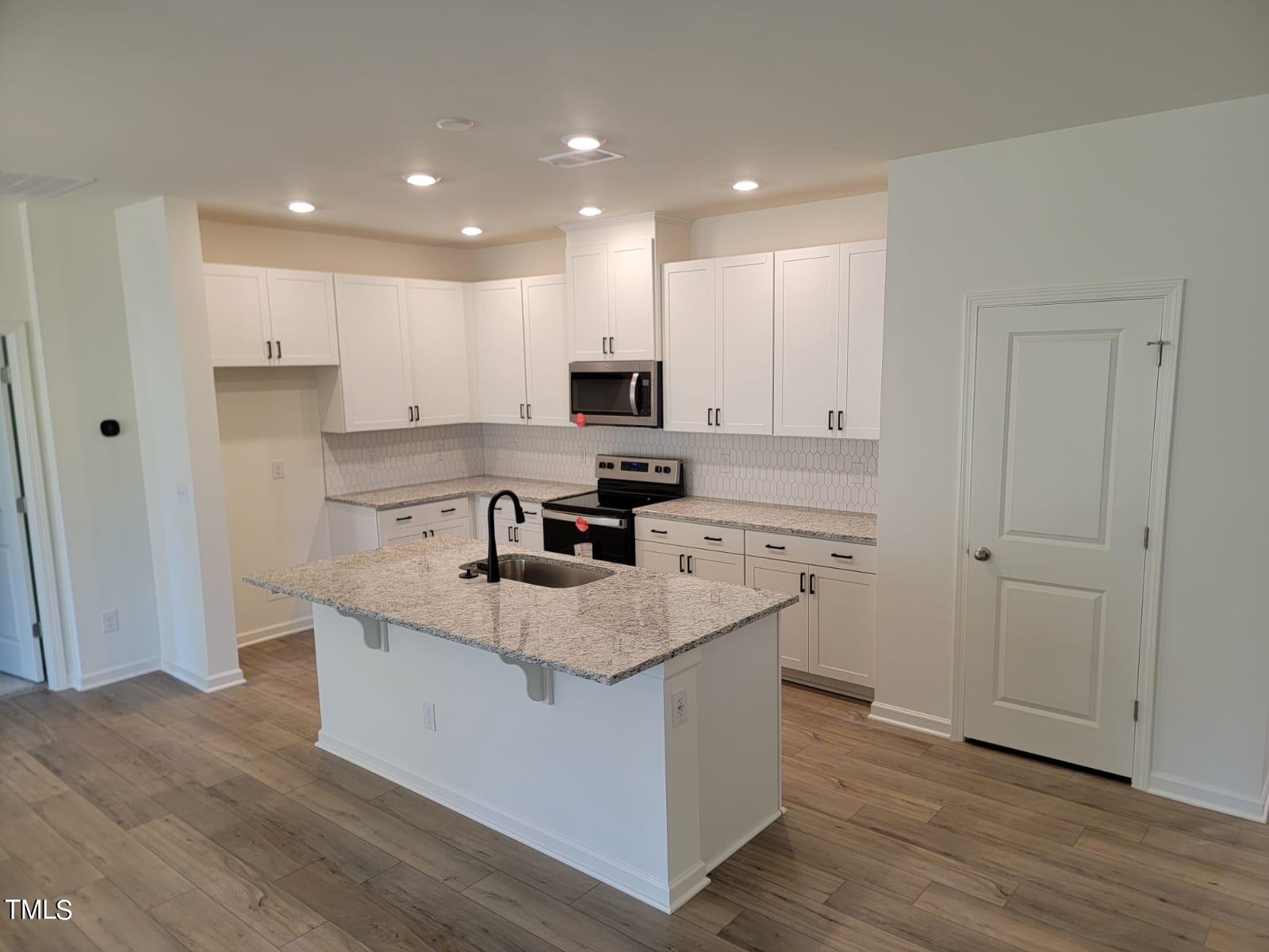1504 Underbrush Drive Durham, NC 27703 - Photo 2 of 15 a kitchen with stainless steel appliances granite countertop a stove top oven a sink and a refrigerator