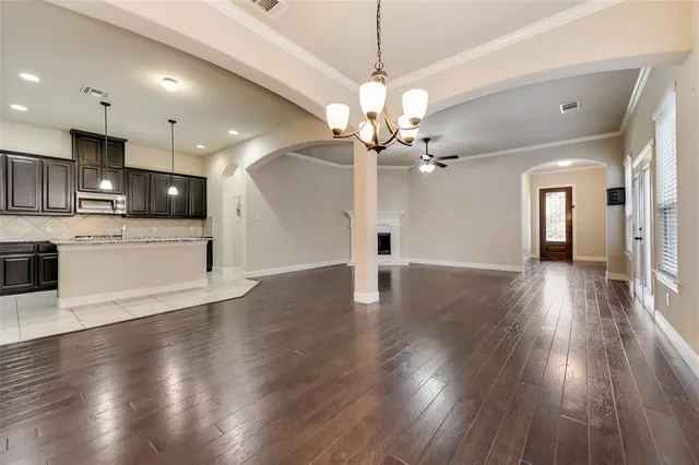 a view of a kitchen with a dishwasher a kitchen island wooden floor and a ceiling fan