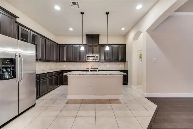 a large kitchen with a large counter top stainless steel appliances and cabinets