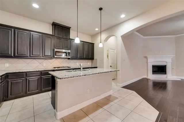 a kitchen with stainless steel appliances granite countertop a sink a stove a microwave and a refrigerator