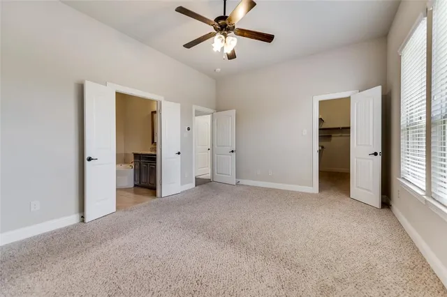 an empty room with closet and a ceiling fan