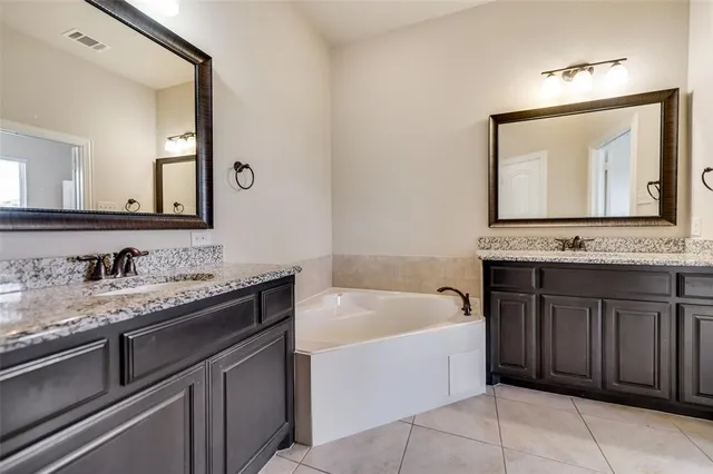 a bathroom with a tub sink and mirror