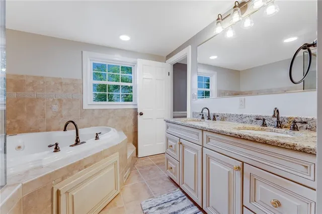 a bathroom with a bathtub sink and mirror