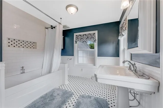 a view of an empty room with wooden floor and a ceiling fan