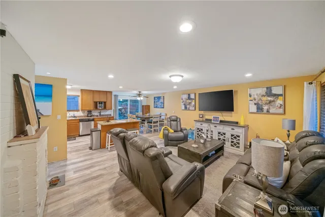a living room with furniture kitchen view and a flat screen tv