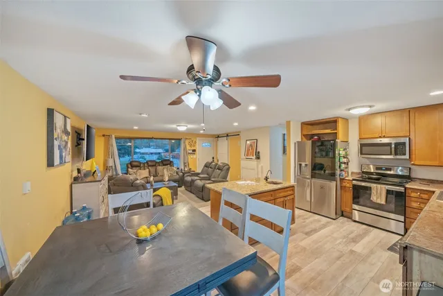 a living room with stainless steel appliances furniture and a kitchen view