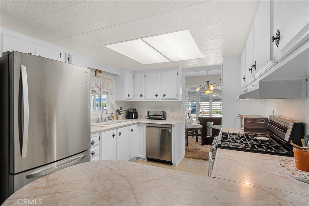 975 California Street, Unit 49 Calimesa, CA 92320 - Photo 11 of 31 a kitchen with stainless steel appliances granite countertop a refrigerator and a stove top oven