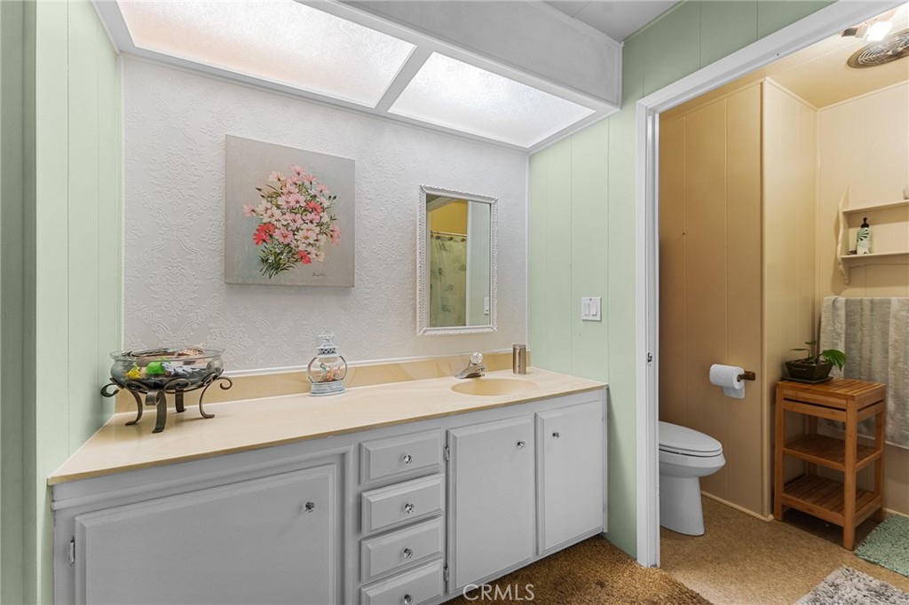 975 California Street, Unit 49 Calimesa, CA 92320 - Photo 19 of 31 a spacious bathroom with a double vanity sink a large mirror a toilet and a window