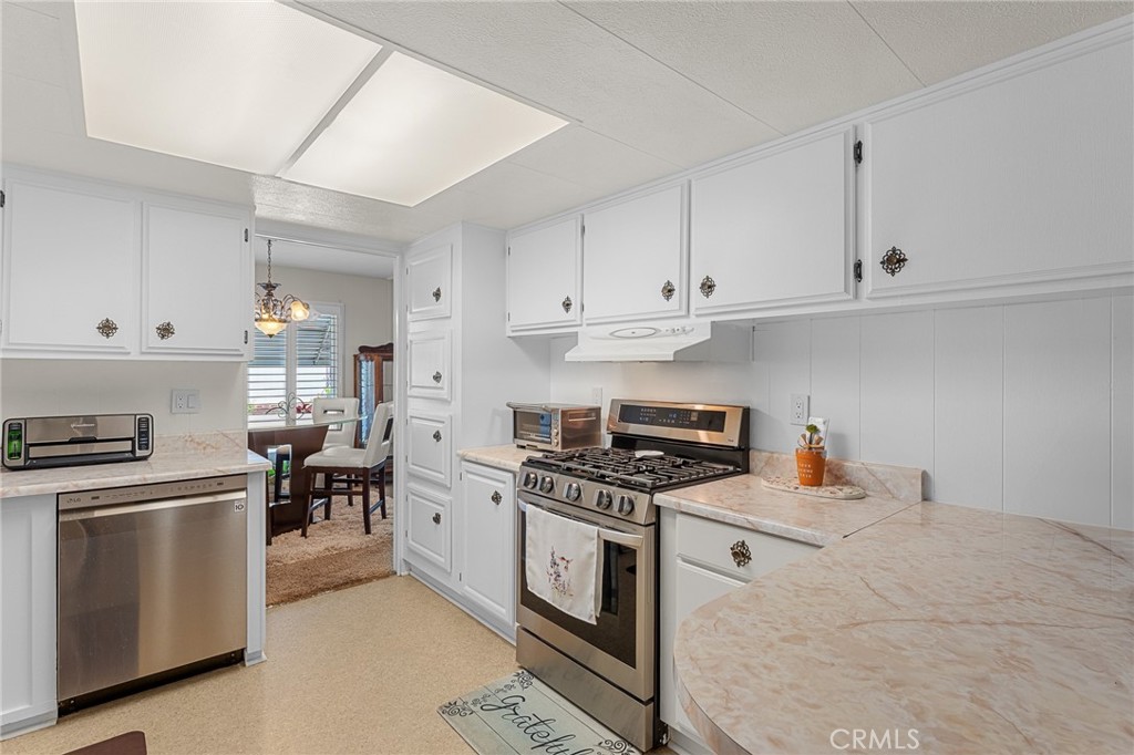 975 California Street, Unit 49 Calimesa, CA 92320 - Photo 9 of 31 a kitchen with stainless steel appliances a stove a sink and cabinets