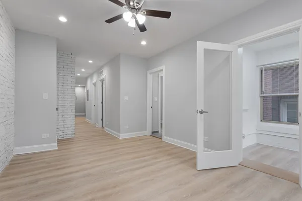 an empty room with wooden floor and entrance