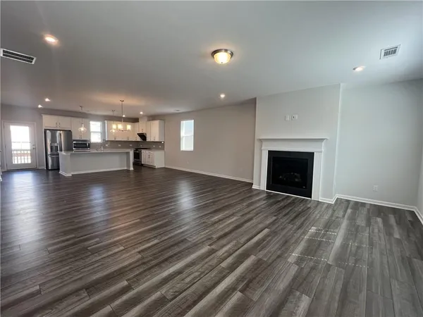 a view of empty room with wooden floor and fireplace