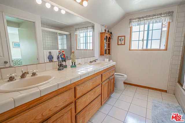 a spacious bathroom with a double vanity sink a mirror and a bathtub