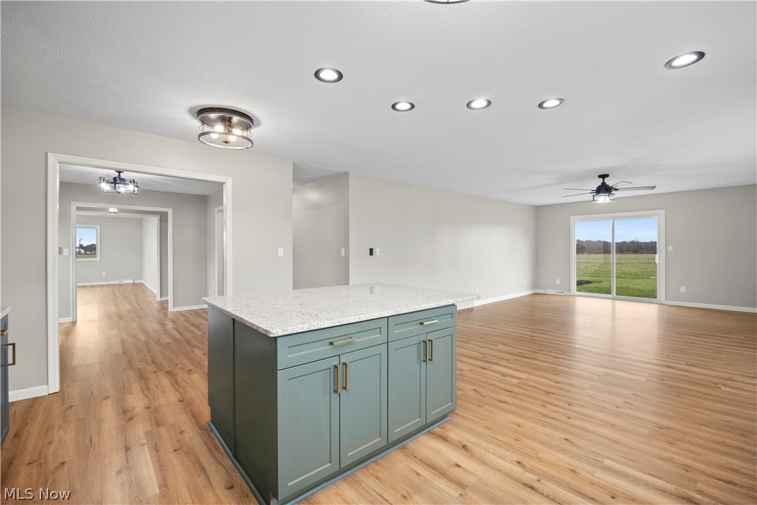 36220 Neff Road Grafton, OH 44044 - Photo 50 of 50 Kitchen featuring a kitchen island, open floor plan, light stone counters, recessed lighting, and light wood-style floors