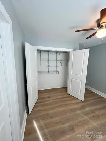 a view of an empty room with closet and a window