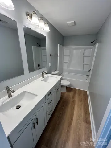 a spacious bathroom with a double vanity sink and mirror with shower