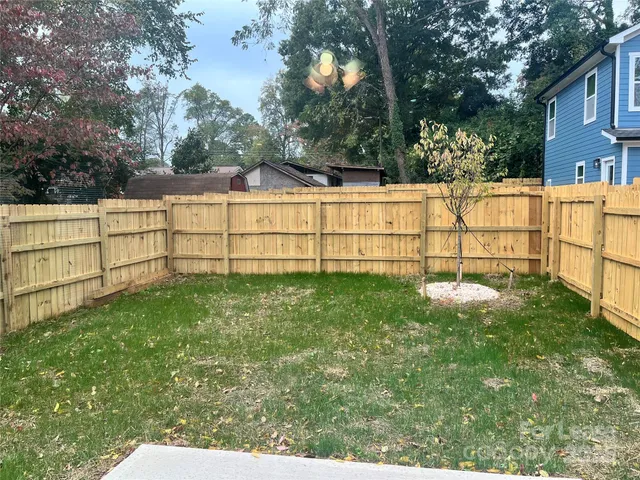 a view of backyard with wooden fence