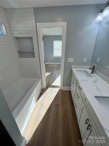 a bathroom with a sink a mirror and a bathtub