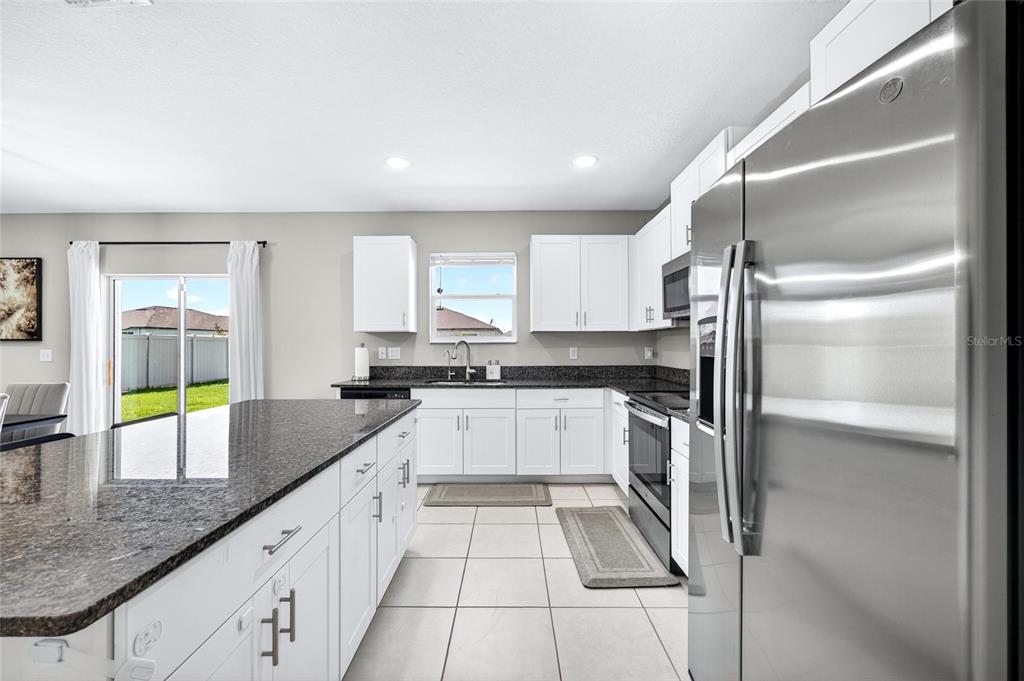 31724 Sun Kettle Loop Wesley Chapel, FL 33545 - Photo 8 of 49 a kitchen with a refrigerator sink and cabinets