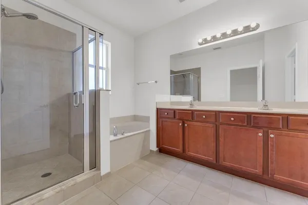 a bathroom with a granite countertop sink a mirror and a bathtub