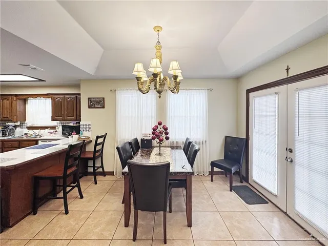 a view of a dining room with furniture and a chandelier