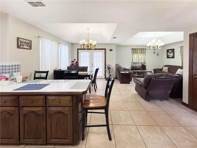 a living room with furniture a chandelier and a dining table