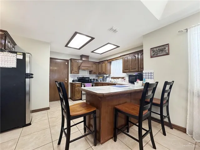 a kitchen with a dining table chairs and refrigerator