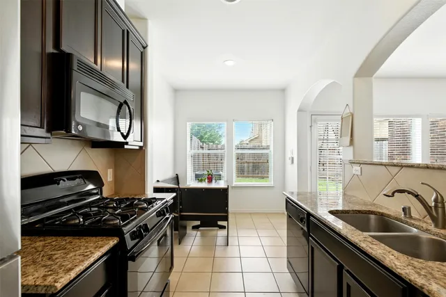 a kitchen with stainless steel appliances granite countertop a sink stove and cabinets
