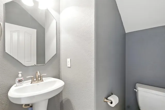 a bathroom with a sink a toilet and mirror