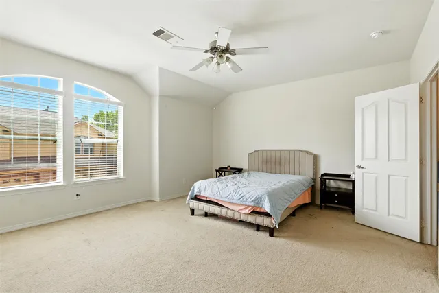 a spacious bedroom with a bed and a chandelier
