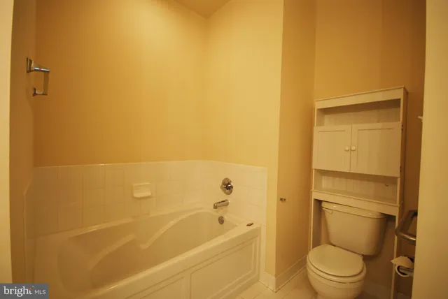 a bathroom with a granite countertop toilet and a bathtub
