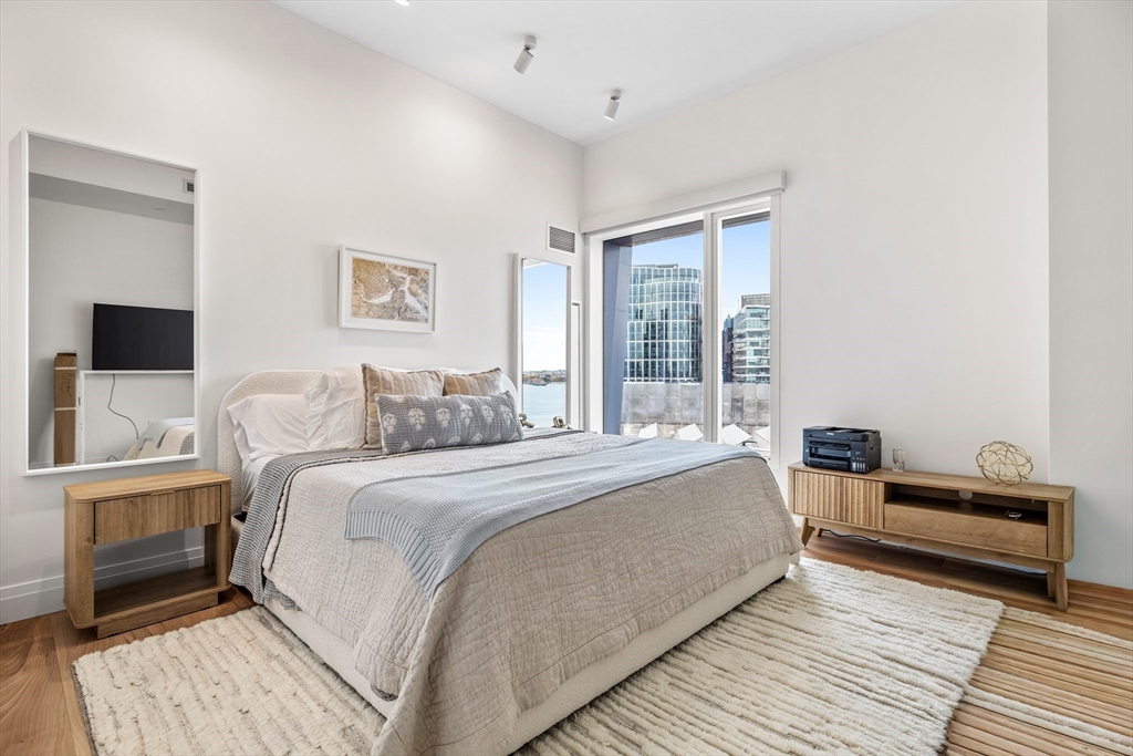 300 Pier 4 Blvd., Unit PHR Boston, MA 02210 - Photo 17 of 28 a spacious bedroom with a bed and a flat screen tv